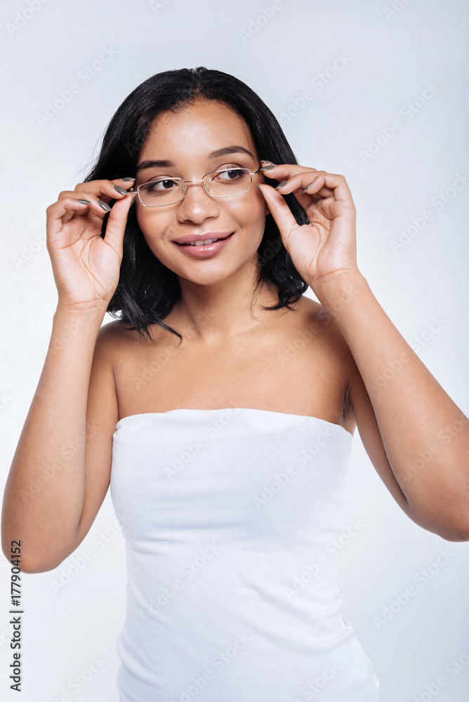 Charming young woman touching rims of eyeglasses Charming young woman touching rims of eyeglasses