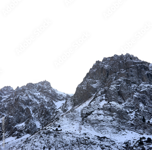 Zaili Alatau shadowed mountains against blind blue sky in winter.