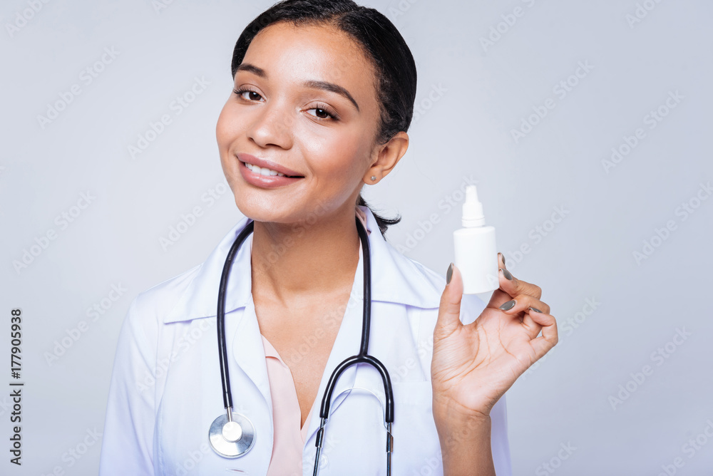 Upbeat female doctor posing with a nasal spray Upbeat female doctor posing with a nasal spray