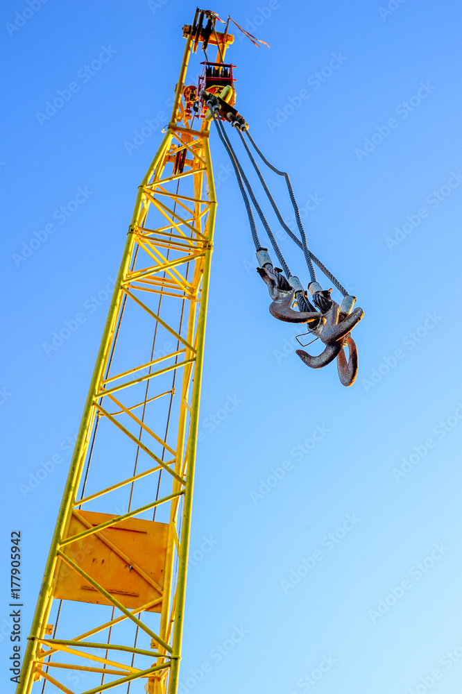 Four empty yellow crane hook hanging down isolated on white background Four empty yellow crane hook hanging down isolated on white background