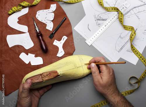 Modelling design of a shoes.Workplace of shoe designer.Hands of designer draw a shoe design .Copy space