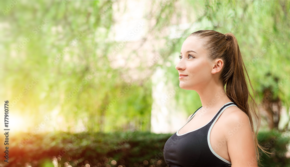 Beautiful smiling young woman with ponytail, breathing fresh air in the park. Woman enjoying yoga, relaxing, got freedom. Copy space background. Side view portrait. Sunlight. Gym, lifestyle concept. Beautiful smiling young woman with ponytail, breathing fresh air in the park. Woman enjoying yoga, relaxing, got freedom. Copy space background. Side view portrait. Sunlight. Gym, lifestyle concept.