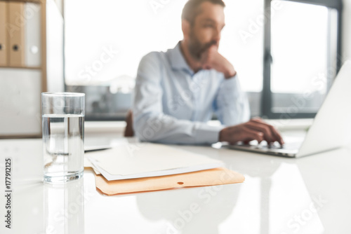 Thoughtful businessman typing on device