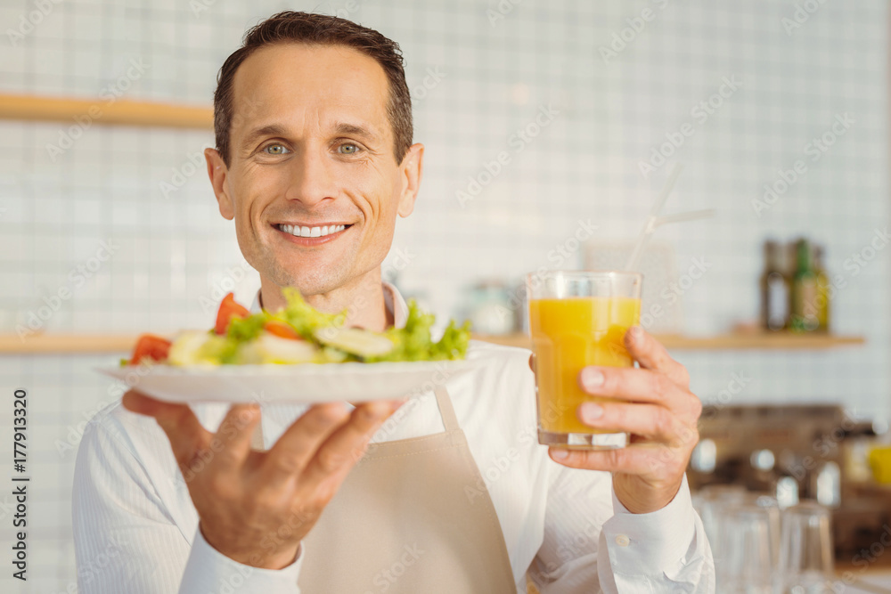 Cheerful happy cook man holding his breakfast Cheerful happy cook man holding his breakfast