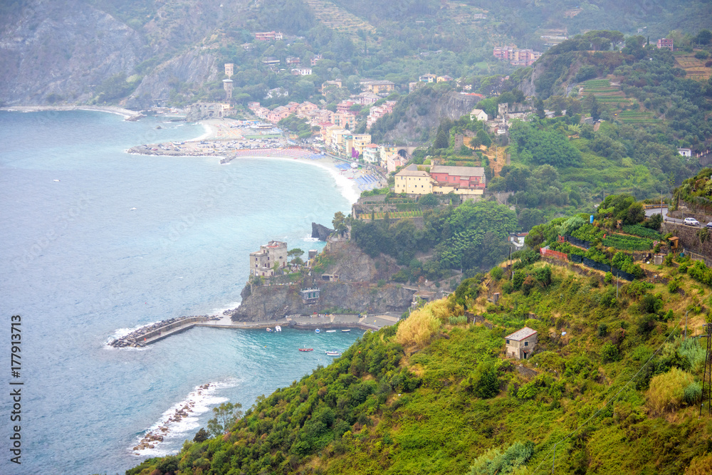 Aerial view to the beach of Monterosso al Mare, Cinque Terre, Italy. Houses, parked cars and beautiful green mountains.