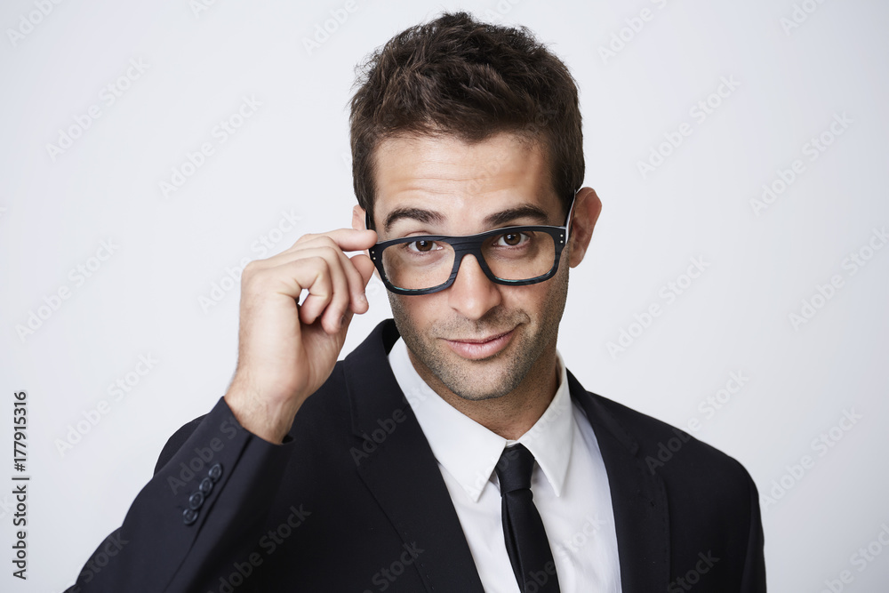 Focused businessman adjusting spectacles, portrait Focused businessman adjusting spectacles, portrait