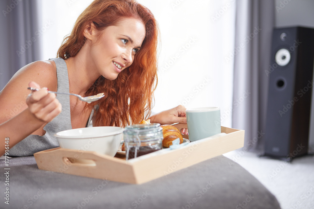 Beautiful happy redhead woman having breakfast in bed Beautiful happy redhead woman having breakfast in bed