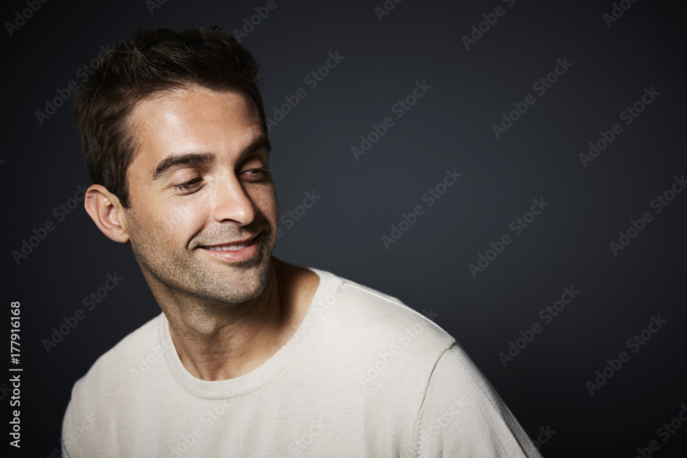 Smiling dude in studio smiling and looking away