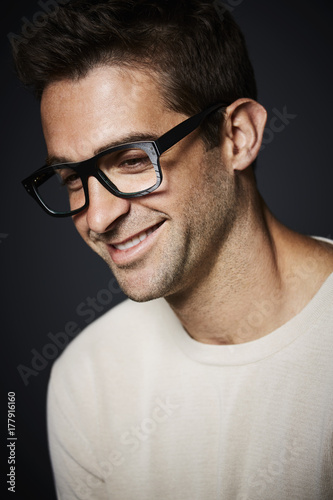 Handsome dude in spectacles smiling in studio