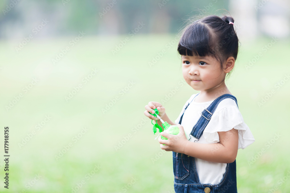 Happy Girl in the garden playing the Bubble