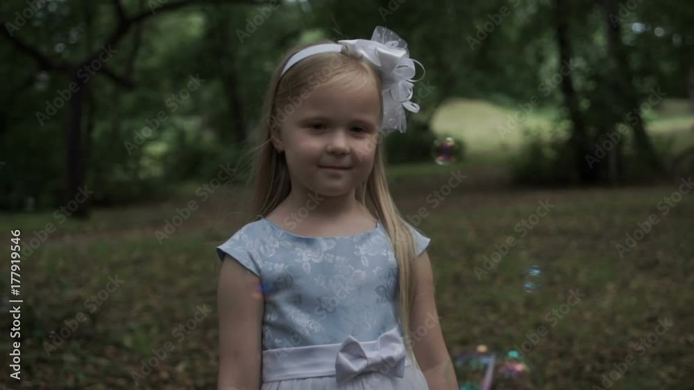 Beautiful little girl in a park on a background of soap bubbles Beautiful little girl in a park on a background of soap bubbles