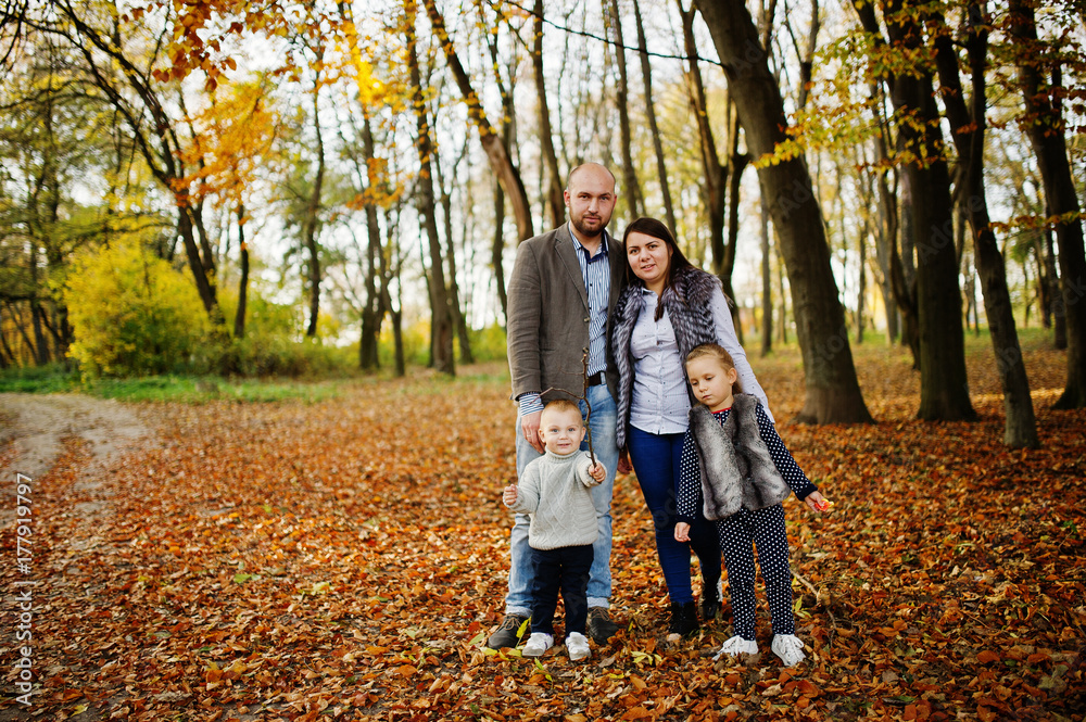 Fototapeta premium Happy caucasian family of mom dad and little girl with boy at majestic autumn fall forest.