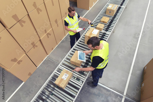     Arbeiter am Fliessband - versenden von Paketen im Onlinehandel // Conveyor belt workers - send parcels in online trade  photo