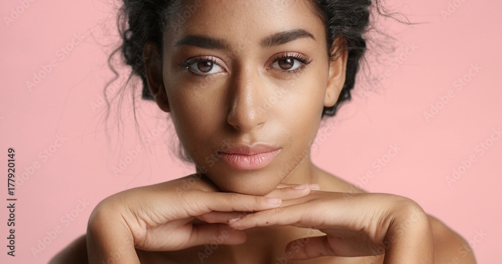 Φωτογραφία Close up video of a happy and relaxed young woman with perfect olive skin fixing