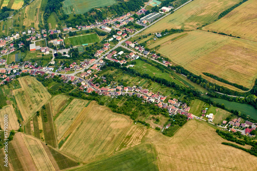 Aerial view of unidentified village in summer countryside during sunset.