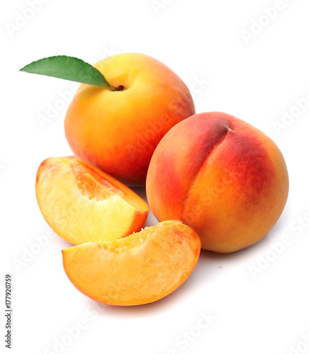 Ripe peach with leaves.