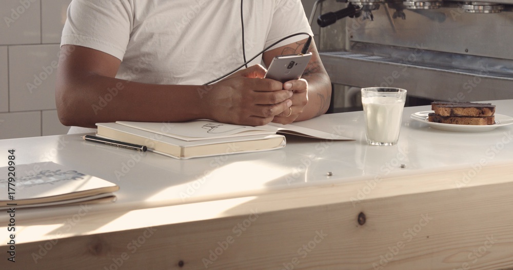mixed race man drawing in sunny loft listening music in earphonesimages with sunny flairs