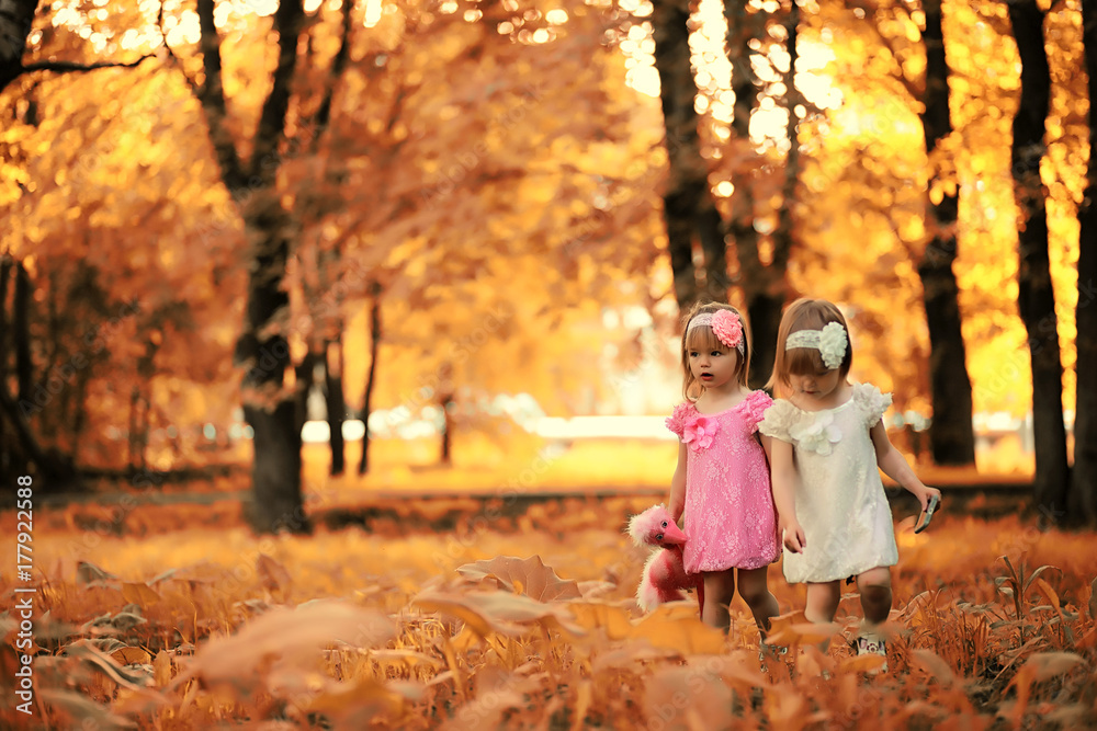 Fototapeta premium Mom with two daughters twins autumn