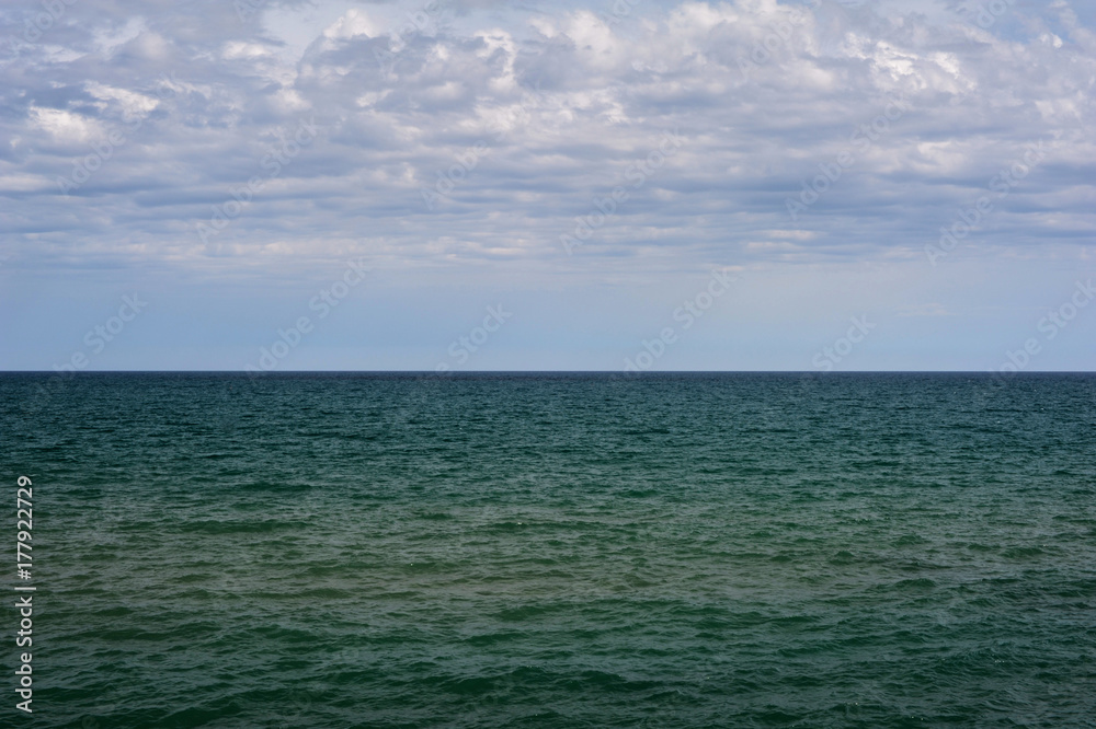 Horizon of mediterranean sea with clouds in the sky