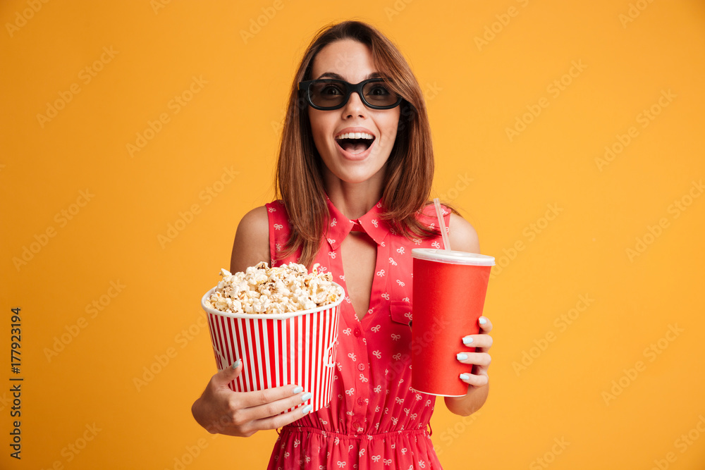 Close-up portrait of happy exited woman in 3d glasses holding cola and popcorn, looking at camera Close-up portrait of happy exited woman in 3d glasses holding cola and popcorn, looking at camera