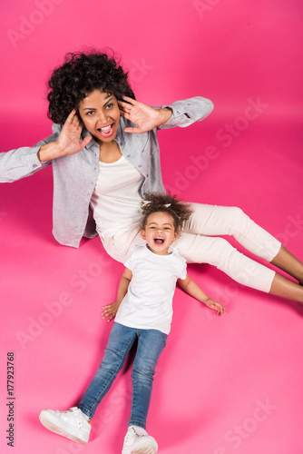 Mother and daughter screaming and sitting on floor