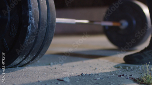 barbell for deadlift and foot athlete powerlifter competitions in powerlifting. Young athlete getting ready for weight lifting training. Powerlifter hand in talc preparing to bench press. legs men photo