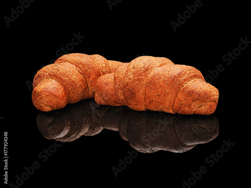 Two whole grain croissant isolated on a black