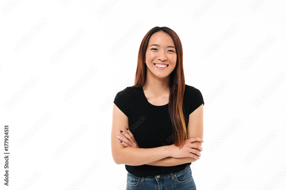 Close-up portrait of smiling young asian girl standing with crossed hands, looking at camera Close-up portrait of smiling young asian girl standing with crossed hands, looking at camera