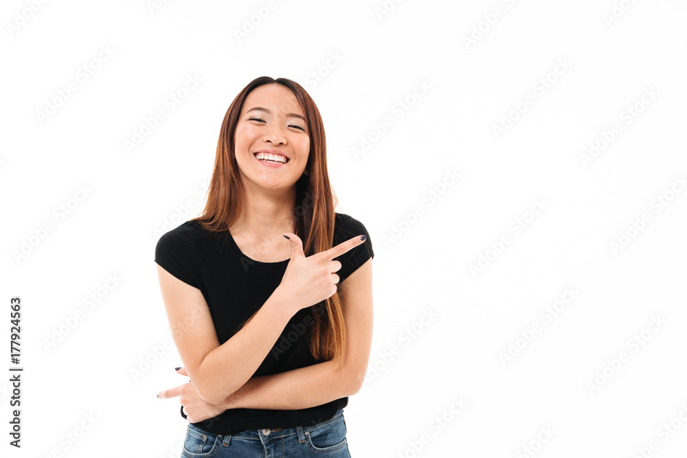 Close-up portrait of beautiful smiling young asian woman pointing with finger, looking at camera Close-up portrait of beautiful smiling young asian woman pointing with finger, looking at camera
