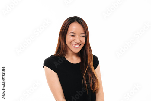 Close-up portrait of laughing attractive asian woman with closed eyes isolated on white background