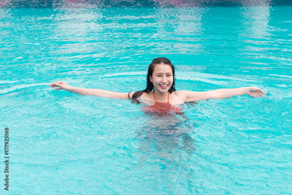 Beautiful asian woman smiling in a swimming pool