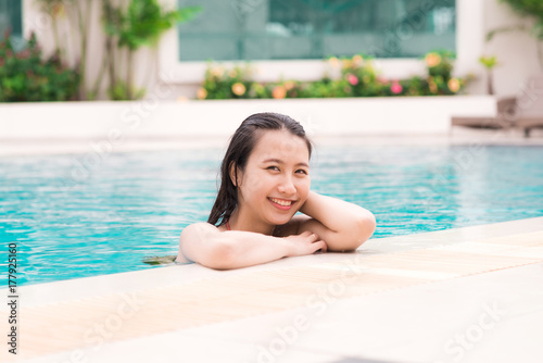 Beautiful asian woman smiling in a swimming pool
