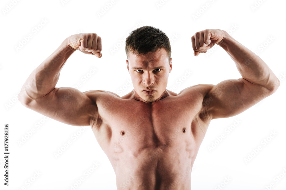Close-up portrait serious bodybuilder showing his biceps, looking at camera Close-up portrait serious bodybuilder showing his biceps, looking at camera
