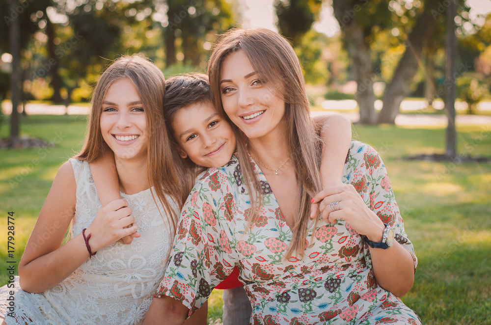 Happy family having fun in the summer at the park. Mom and children.