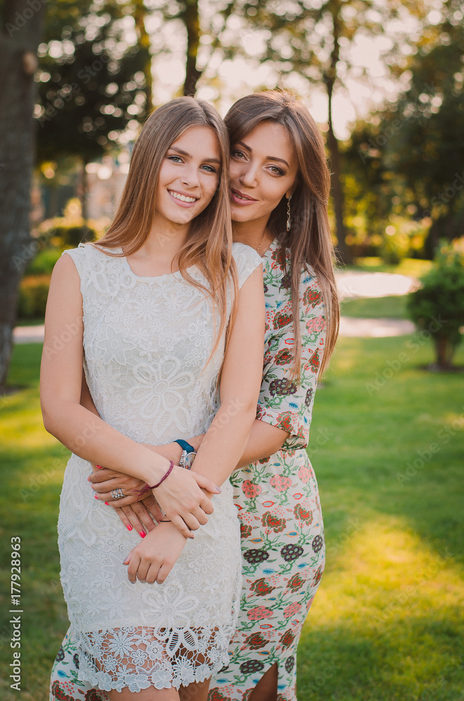 Love of mother and daughter. A happy mother and daughter are resting in a summer park. Happy family concept Love of mother and daughter. A happy mother and daughter are resting in a summer park. Happy family concept
