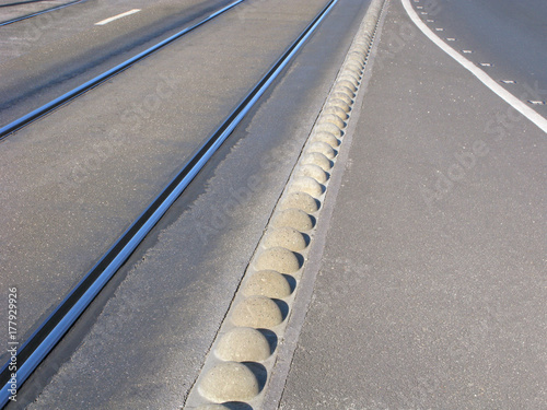 Stone separation barrier between tram tracks and car road. 