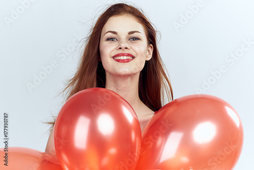 red balloons and the face of a smiling woman on a white background