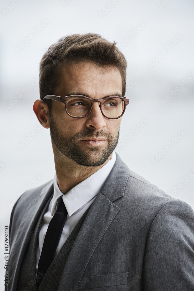 Serious businessman in glasses, looking away Serious businessman in glasses, looking away