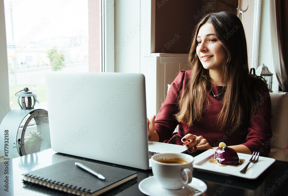Young attractive woman sitting in a cafe in the morning before her work and planning tasks for the whole day. Beautiful lady talking on the phone and discussing business strategies with her colleague. Young attractive woman sitting in a cafe in the morning before her work and planning tasks for the whole day. Beautiful lady talking on the phone and discussing business strategies with her colleague.