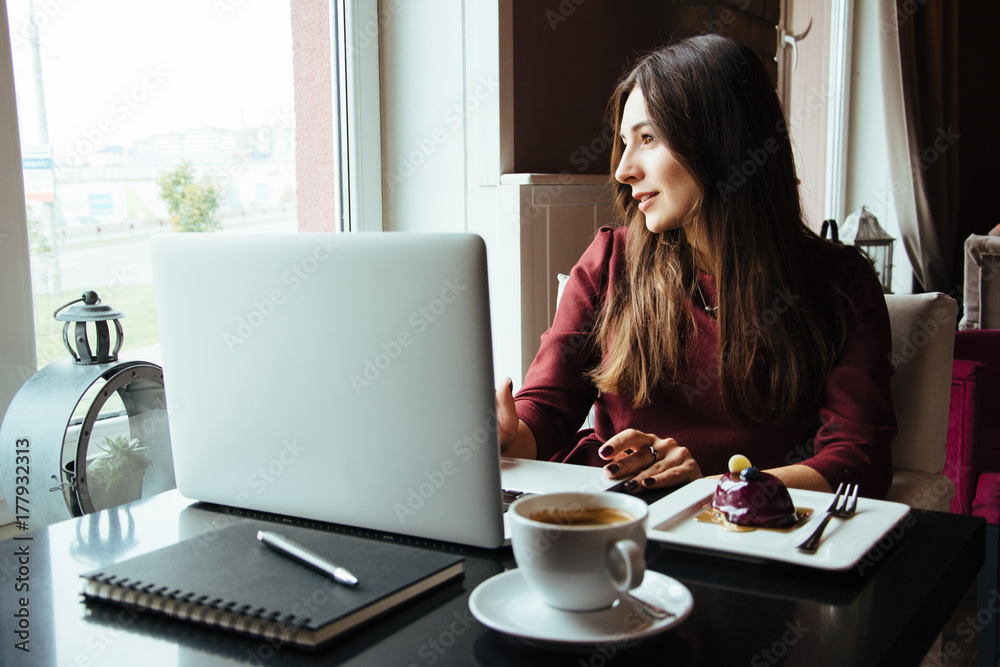 Young attractive woman sitting in a cafe in the morning before her work and planning tasks for the whole day. Beautiful lady talking on the phone and discussing business strategies with her colleague. Young attractive woman sitting in a cafe in the morning before her work and planning tasks for the whole day. Beautiful lady talking on the phone and discussing business strategies with her colleague.