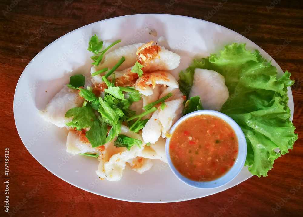 Fish fillets baked with  sauce with herbs.