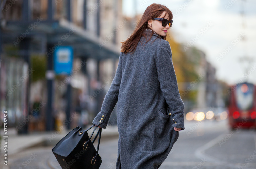 Trendy fashion woman in coat walking on the street, city scene - obrazy, fototapety, plakaty 