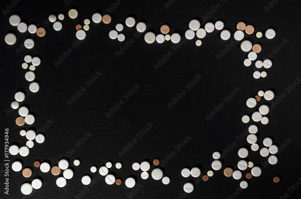 Frame of pills on a dark background with free space for text, top view