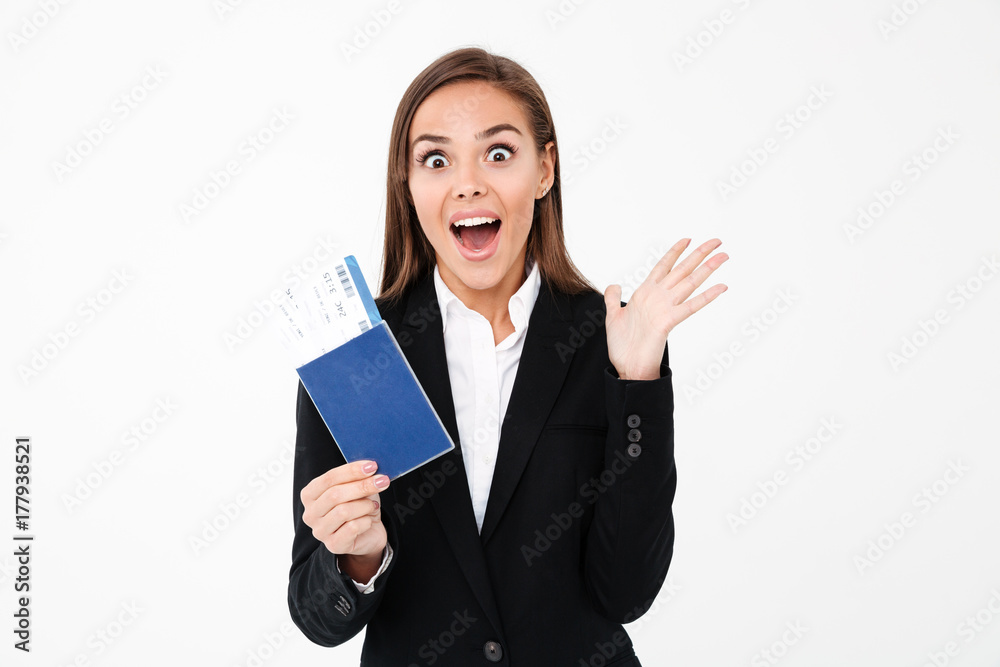 Surprised excited pretty businesswoman holding tickets and passport Surprised excited pretty businesswoman holding tickets and passport