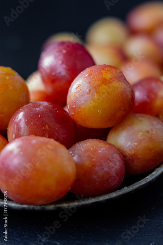 Ripe and beautiful wild plum fruits over black background.