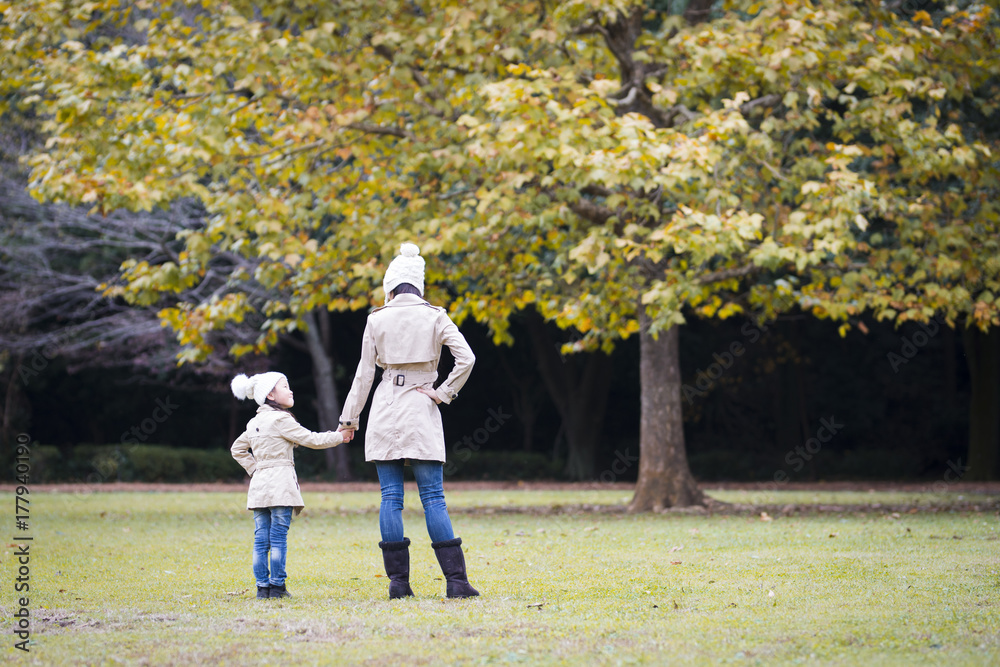 Fototapeta premium Mother and daughter playing in autumn park