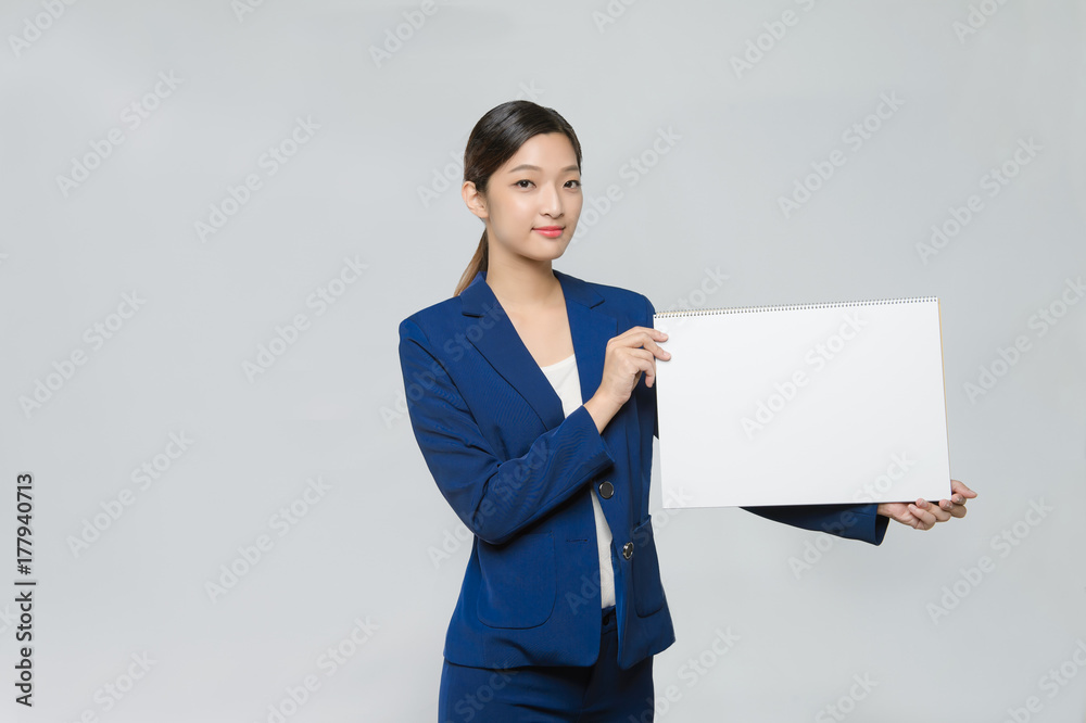 asian woman holding white blank cardboard, over gray background. asian woman holding white blank cardboard, over gray background.