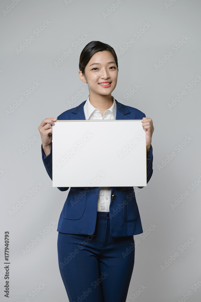 asian woman holding white blank cardboard, over gray background. asian woman holding white blank cardboard, over gray background.