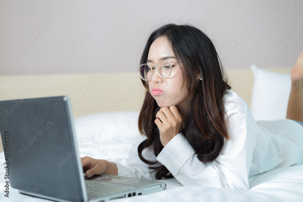 Asia cute girl with computer notebook on the bed. Asia cute girl with computer notebook on the bed.