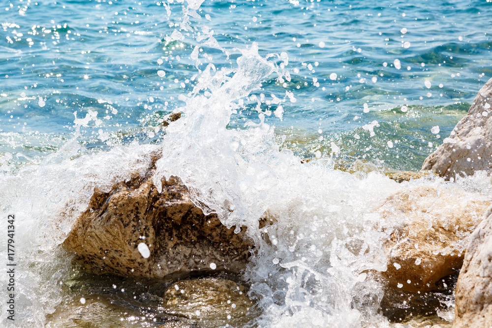 Fototapeta premium waves break against the rocks 